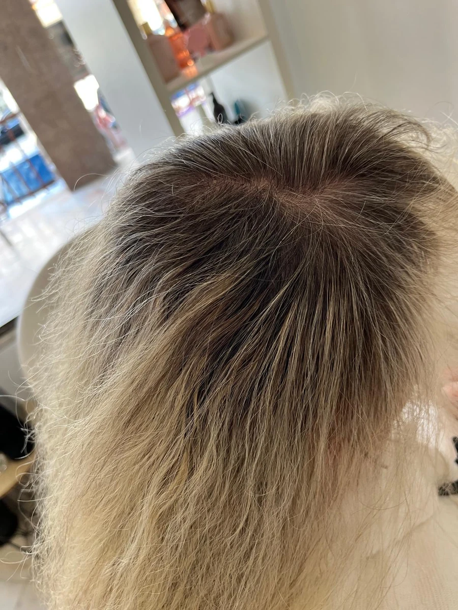 Cabelo loiro com a raiz escura à vista, antes do retoque de raiz